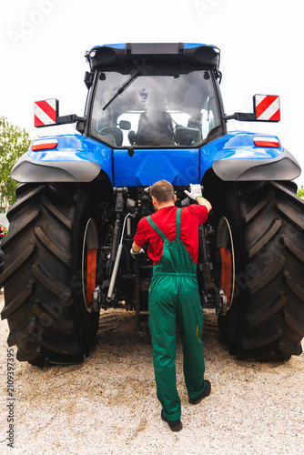 Male mechanic repairing a tractor.