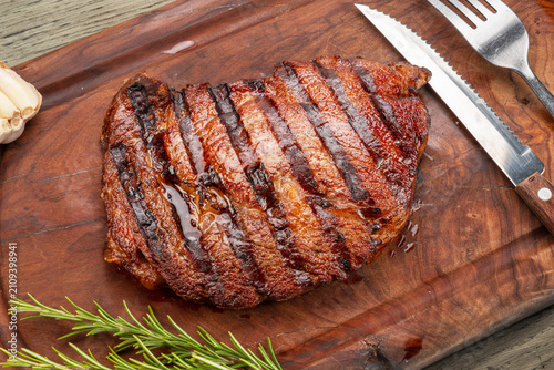 Bild auf Leinwand Grilled beef ribeye steak with rosemary on wooden cutting board.