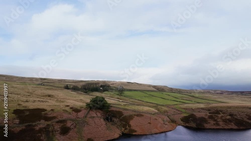 Yorkshire Moorlands in the English countryside. Bleak barren moors or pennines. Calm lake with heather covered hills.