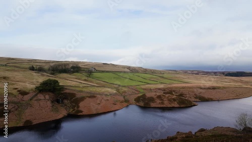 Yorkshire Moorlands in the English countryside. Bleak barren moors or pennines. Calm lake with heather covered hills.