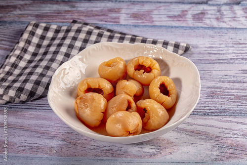 Fotografie Candied fruit pieces in white ceramic bowl on rustic wooden table