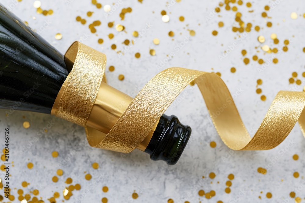 Fototapeta premium The Champagne Bottle Wrapped in Golden Ribbon for Festive Celebration