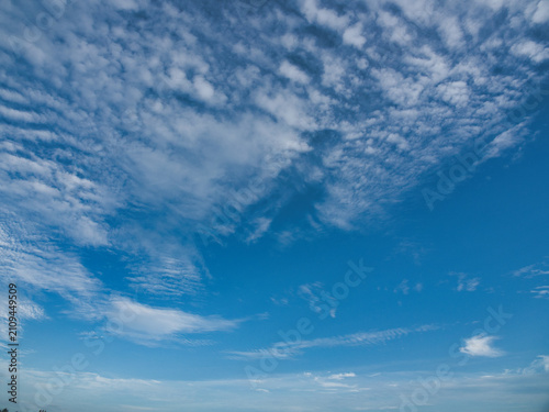 Fotografie Clear blue sky with thin white clouds forming patterns resembling fish scales or ripples—specifically cirrocumulus clouds often referred to as a buttermilk sky