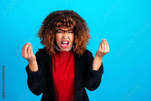 Quadro su tela Angry young woman making an expressive hand gesture of frustration while shoutin