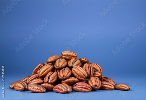 Pile of pecan nuts on blue ...