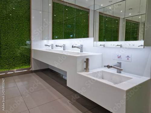 Canvas-taulu Modern public restroom with white sink counter, chrome faucets, sink for childre
