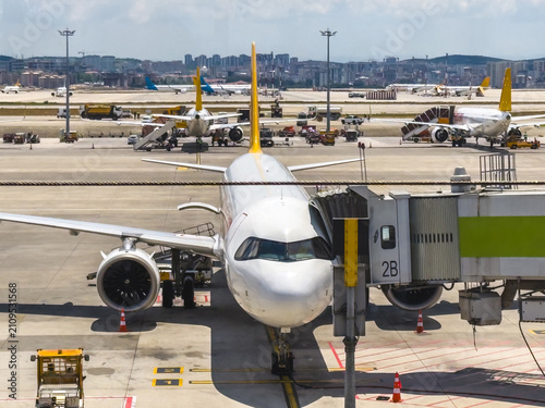 Commercial passenger aircraft parked at busy international airport terminal apron
