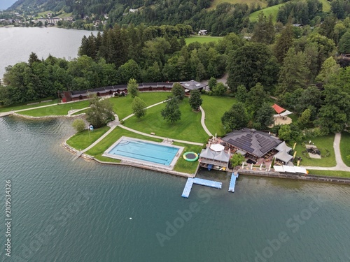 Fotografía Zell am See, Austria - June 08 2026: Drone flying over the lake, following a boat, beautiful sunset and weather