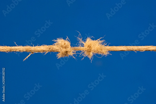 fraying rope on blue background