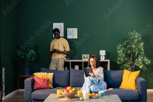 Fotografie Couple interacting with digital devices at home