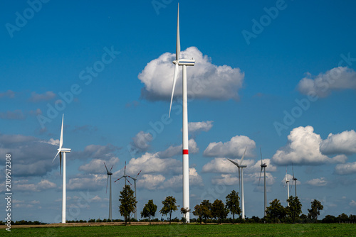 Canvas Print Wind turbines generating clean green energy on a sunny day with blue sky and white clouds