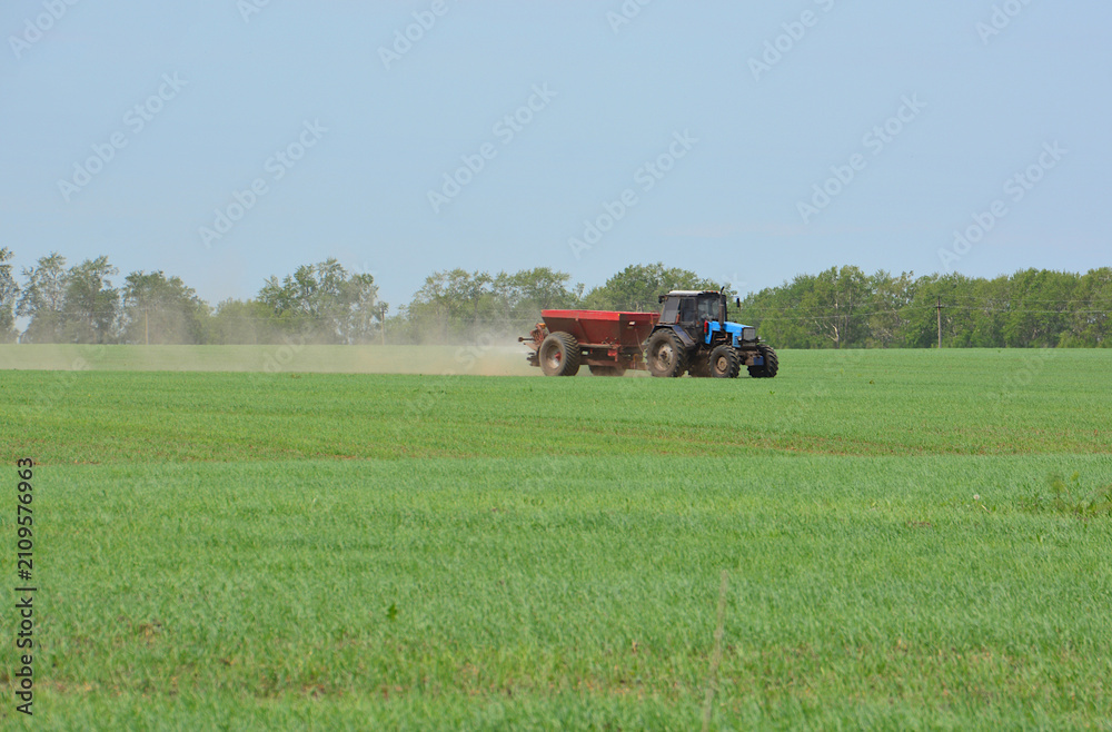 Obraz premium Tractor Spreading Fertilizer in Agricultural Field front view