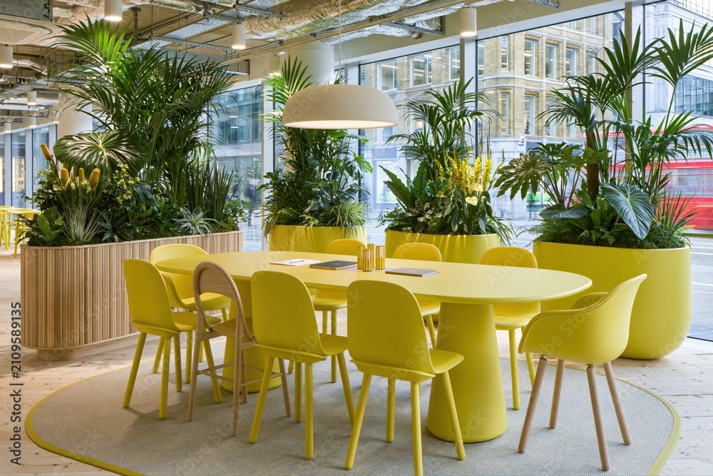 Obraz premium Modern Office Meeting Room with Yellow Furniture and Lush Green Plants