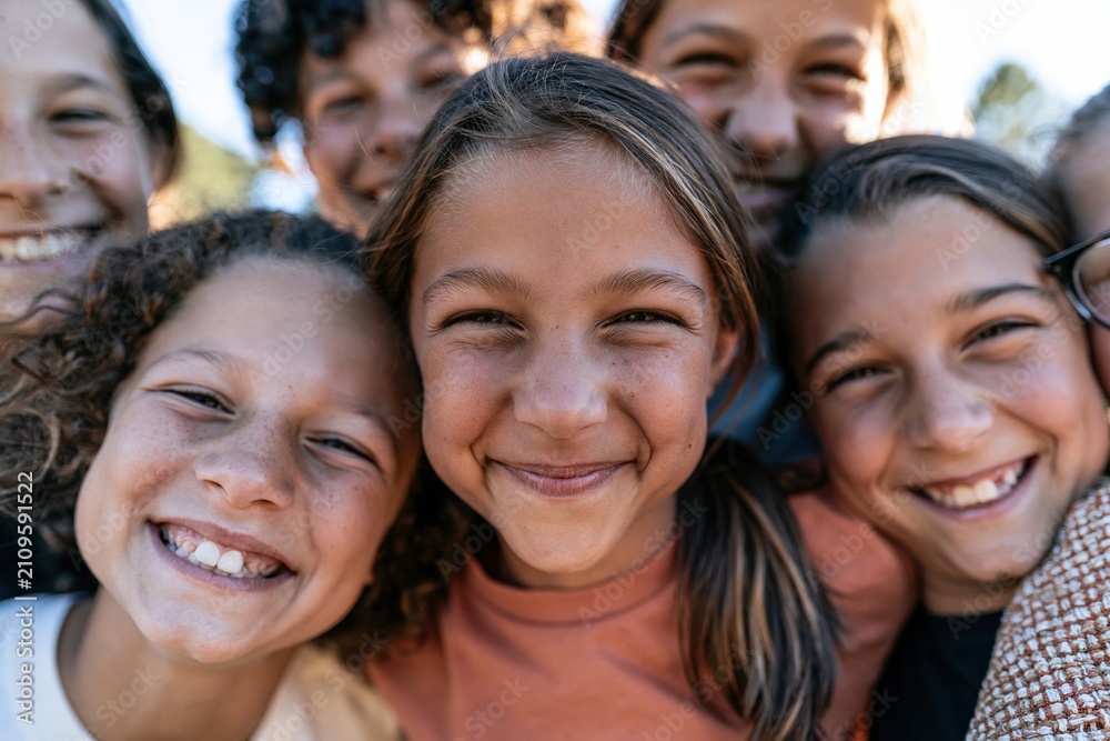 Fototapeta premium Close up of diverse preteen friends smiling in a joyful group huddle, capturing sun-drenched skin and natural expressions for youth recreation campaigns