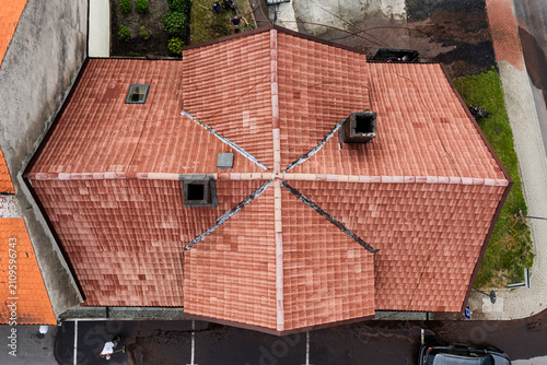 Roof with roof tiles cleaned by pressure washing, showing freshly washed surface prepared for painting, residential building rooftop maintenance with detailed texture and restoration process