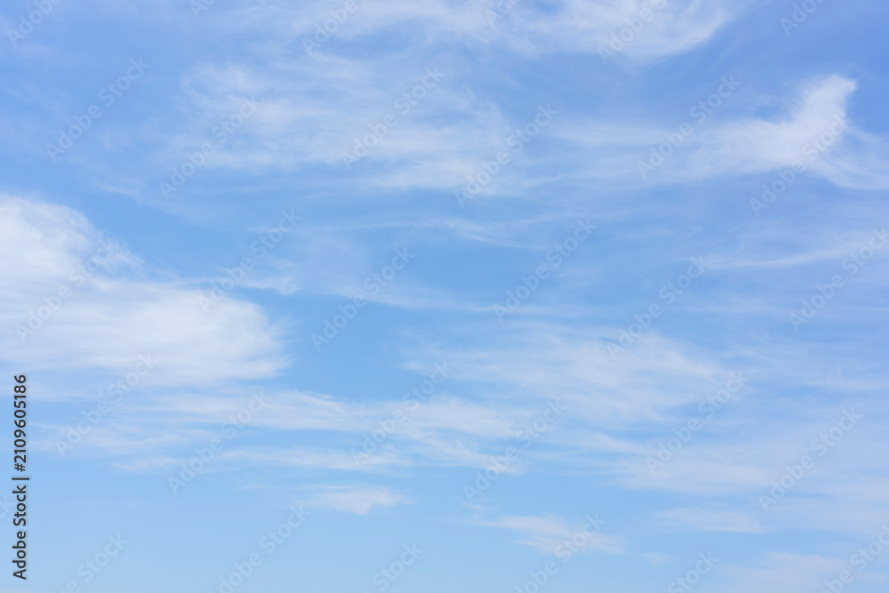 Naklejka premium Clear blue sky with soft white clouds scattered throughout, creating a serene and tranquil atmosphere ideal for backgrounds or nature-themed projects
