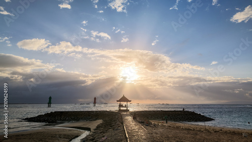 Tableau sur toile Sunrise Silhouette of Gazebo and Stone Jetty with Sun Rays over Sea