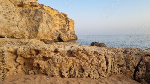 Quadro su tela Weathered limestone cliffs with natural caves under clear blue sky on Mediterran