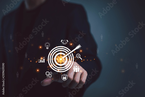 Business professional selecting a virtual target icon with strategy and analytics symbols, representing goal achievement, business planning performance optimization, leadership, digital transformation