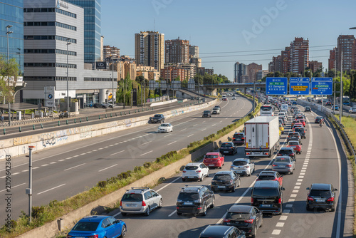 Tableau sur toile Wider view of Madrid's gridlocked A-1 motorway approaching the M-30, with directional signs and dense city skyline beyond