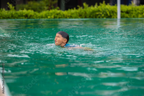 Fotografía Little asian school boy swim and buoyancy practice in swimming pool