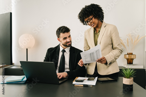 African American businesswoman presenting financial documents during a professional office meeting, reviewing positive results 