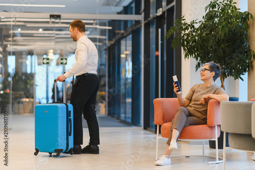 Photography Bellboy assisting guest in hotel lobby with luggage