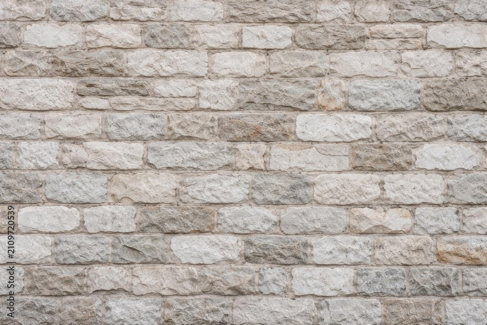 Fototapeta premium Textured Stone Wall with Soft Neutral Tones and Varied Surface Patterns