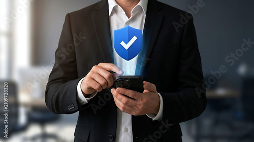 Businessman holding smartphone with cyber security shield icon for data protection