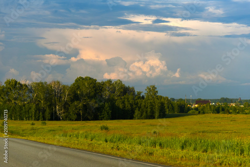 Foto The evening horizon is covered with thunderclouds and a field with a forest