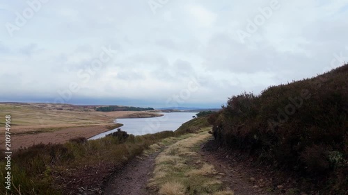 Yorkshire Moorlands in the English countryside. Bleak barren moors or pennines. Calm lake with heather covered hills.