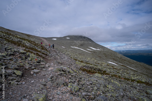Bild auf Leinwand Hikers on Rocky Trail Ascending Gaustatoppen Mountain, Telemark Norway