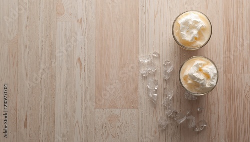 Valokuva Creamy Dessert with Whipped Topping and Ice on Light Wooden Surface