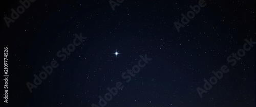 Bright Star Illuminating the Night Sky Amidst Twinkling Stars