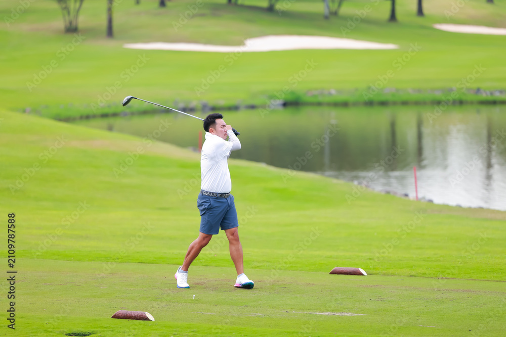 Fototapeta premium professional golfer on field. Asian Man Golfer Hitting Golf Shot on golf Course. teeing off golf ball. Sport outdoor