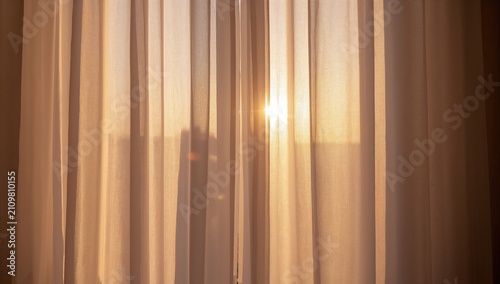 Sunset Light Streaming Through Sheer Curtains in Warm Glow