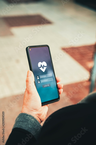 Health App Login Screen on Smartphone Held by Woman's Hand Outdoors. Digital healthcare, telemedicine, mobile wellness tracking, and cybersecurity in health tech concept.