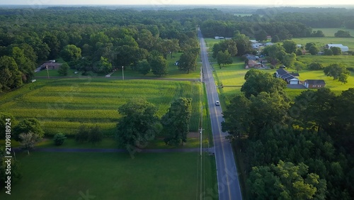 Early morning in Tennessee countryside with country road and homes in rural America beside green pastures and farmland