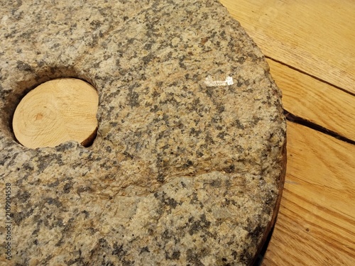Bild auf Leinwand Large stone millstone with a wooden insert on a heated floor