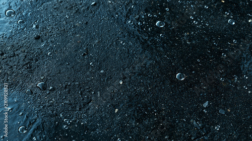 Wet asphalt after rain texture with water beads, dark graphite