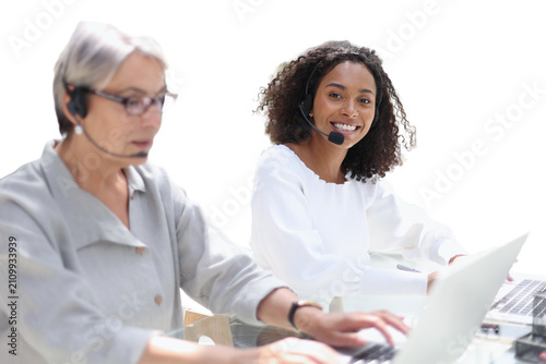 Young friendly operator woman agent with headsets working in a call centre.