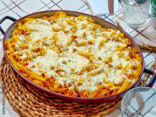 Baked penne pasta in tomato sauce with melted cheese