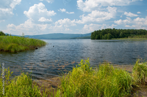 Lake Turgoyak in the middle of summer surrounded by green forest, South Ural, Russian Federation