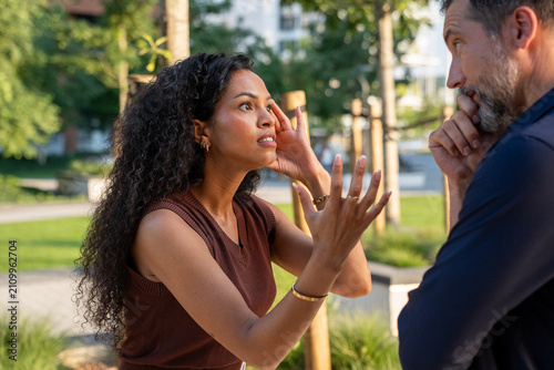Fotografie Frustrated woman arguing with uninterested man outdoors, relationship conflict a