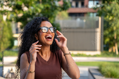 Smiling woman using AR glasses in city park