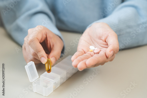 Sick, illness asian young woman, girl holding vitamins fish oil, pills preparing to put in pill box for medication to take daily, pain for treatment, take drug or vitamin, health care person concept.