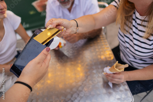 Woman paying for purchases with credit card at cafe