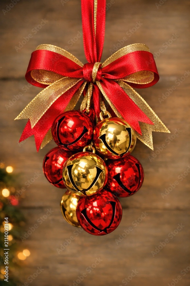 Fototapeta premium A decorative arrangement of red and gold ornaments hanging from a ribbon, perfect for festive occasions or gift wrapping