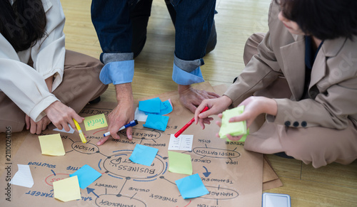 Close-up of business team writing sticky notes during strategy brainstorming meeting