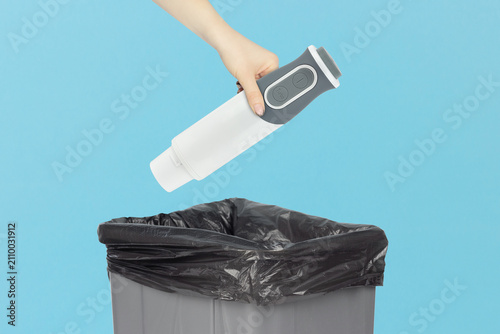 Throwing a electric stick mixer handle grip piece into the trash can, holding a electric stick mixer handle grip piece in hand front of the trash can
